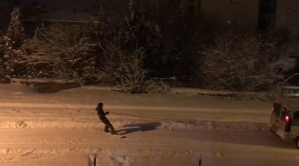 Araca arkasına bağladığı iple karda kayak yaptı